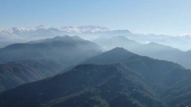 Türkiye 'nin kuzeyindeki Trabzon' da yağmur mevsiminde yemyeşil yağmur bulutları içindeki bir köyün havadan görünüşü yağmur ormanları dağını örtüyor    