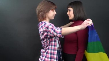 Lezbiyen çift, mutlu kız homoseksüel dans ve bayrak ile eğlenme sembolik ifade LGBTQ bayrağı