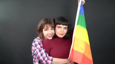 Lezbiyen çift, mutlu kız homoseksüel dans ve bayrak ile eğlenme sembolik ifade LGBTQ bayrağı