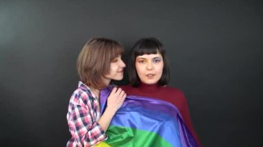 Lezbiyen çift, mutlu kız homoseksüel dans ve bayrak ile eğlenme sembolik ifade LGBTQ bayrağı