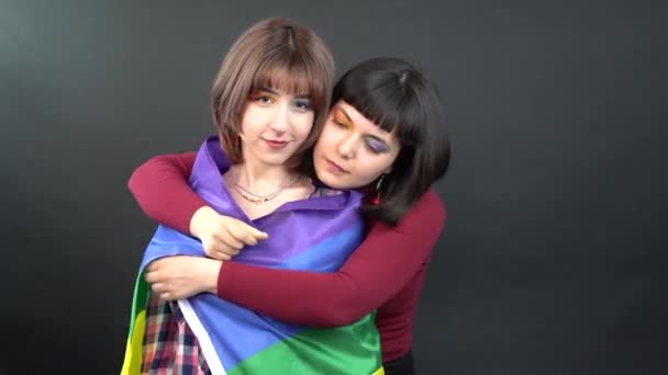 レズビアンカップル 幸せな女の子の同性愛ダンスと旗の象徴的な表現で楽しみを持っていますLgbtqフラグ — ストック動画