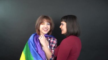 Lezbiyen çift, mutlu kız homoseksüel dans ve bayrak ile eğlenme sembolik ifade LGBTQ bayrağı. 