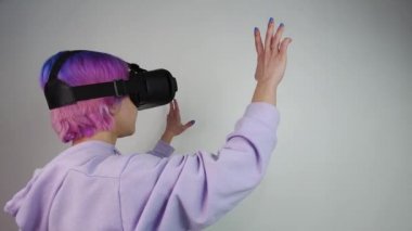 VR gözlük takan kadın havaya dokunuyor.   