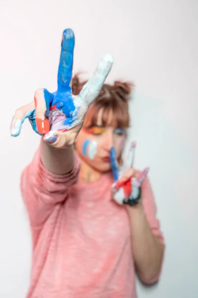 Mutlu kadın eller gösterilen beyaz arka plan üzerinde renkli boya boyalı. Eğlenceli kavramı  