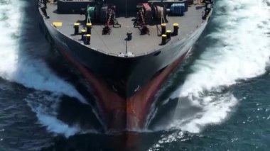 Ağır yüklü bir konteynır gemisinin hava görüntüsü sakin, mavi deniz üzerinde seyahat ediyor.