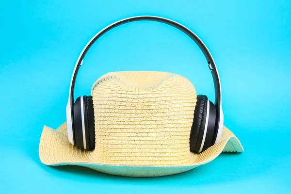 Hat in white wireless headphones on blue background. The concept of rest, relaxation. — Stock Photo, Image