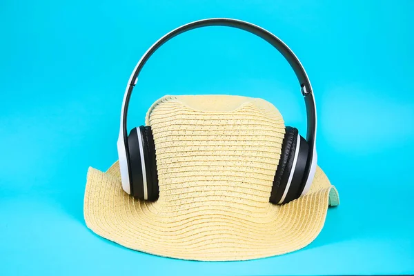 Hat in white wireless headphones on blue background. The concept of rest, relaxation. — Stock Photo, Image