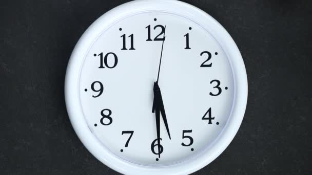 Белые часы на черном фоне. Вторичная рука идет до 6 часов. Вечер или утро. — стоковое видео
