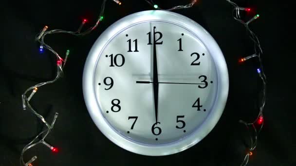Reloj blanco junto a la guirnalda. La segunda mano va a las 6 pm. Preparación para el Año Nuevo, Navidad. — Vídeos de Stock