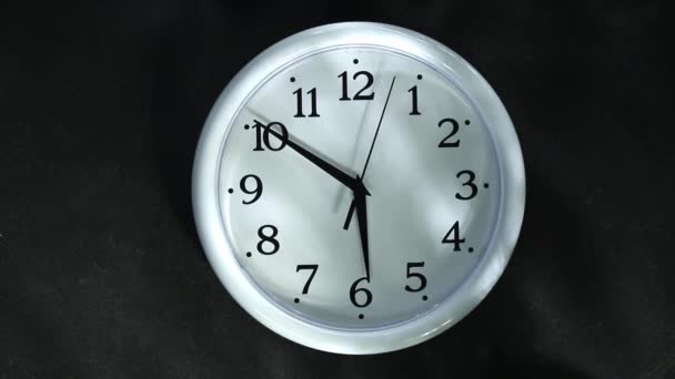 黒を背景に白い時計。2番目の手は6クロックになります。夕方または朝. — ストック動画