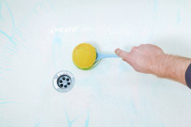 Bir adam banyo temizleyicisi uygular ve banyoyu fırçayla ovar, paçavra. Banyoyu temizliyorum..