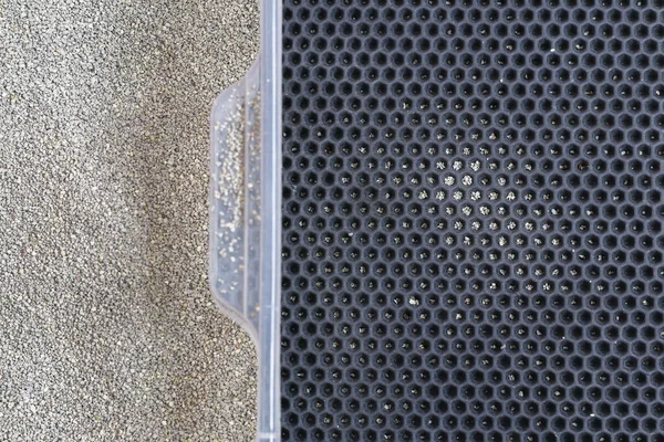 Uma caixa de areia com areia de aglomeração senta-se em um colchão de EVA de favo de mel. Pequenas partículas de enchimento dos pés — Fotografia de Stock