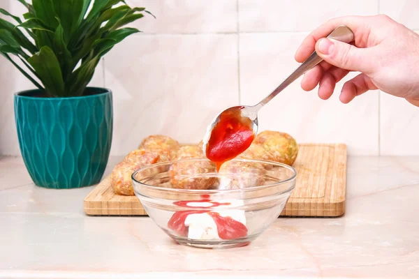 A man puts tomato paste, ketchup for pouring to cook lazy cabbage rolls in slow cooker. — Fotografia de Stock