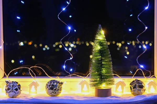 New Years Christmas tree on the window on background of the night city. Garlands, lights, bokeh. — Stock Fotó