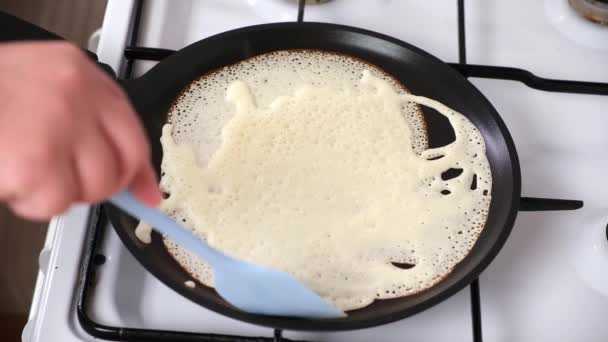 La donna gira la frittella in padella. Le crepes vengono fritte in una padella sul fornello. Pancake cottura — Video Stock