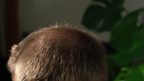 Un homme se fait couper les cheveux avec une tondeuse électrique à la maison. Coupe de cheveux à la maison. Économies sur un coiffeur. — Video