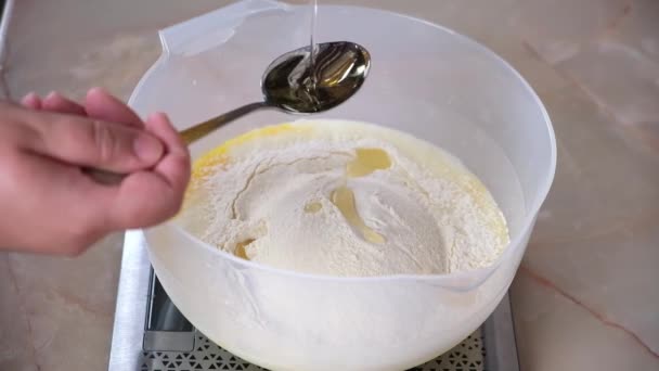 Una donna versa olio di girasole in una pastella di pancake. Crepes da cucina. — Video Stock