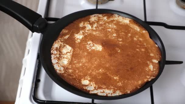 Le crepes sono fritte in padella sui fornelli. Processo di cottura dei pancake. Blini russi. — Video Stock