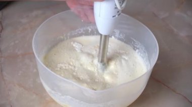 Bir kadın krep hamurunu blender ile dövüyor. Krep pişiriyorum..