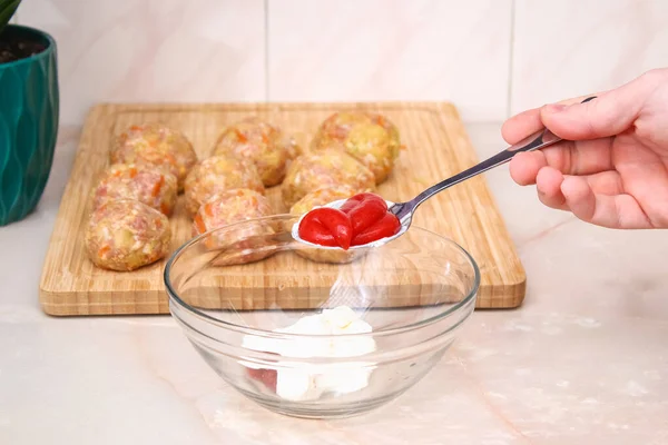 Мужчина кладет томатную пасту, кетчуп для розлива, чтобы приготовить ленивые капустные рулетики в медленную плиту. — стоковое фото