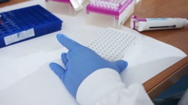 Bilim adamı, kimya laboratuvarında örnek toplamak için çok kanallı Pipette kullanıyor.