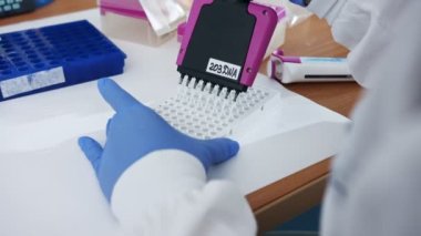 Bilim adamı, kimya laboratuvarında örnek toplamak için çok kanallı Pipette kullanıyor.