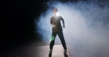 Genç bayan dansçı yavaş çekimde hip hop dansı yapıyor.