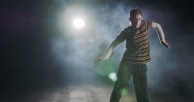 Genç bayan dansçı strobe light ve dumanla hip hop dansı yapıyor.