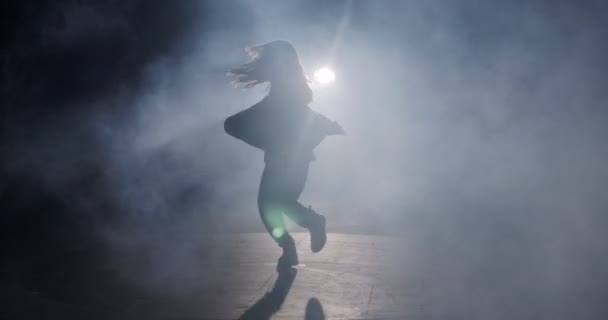 若い女性ダンサーパフォーマンス野生のヒップホップダンスとともにストロボ光と煙の背景 — ストック動画