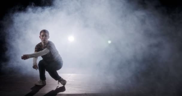 Silhouette d'une danseuse exécutant une danse hip hop au ralenti avec fond de lumière et de fumée — Video