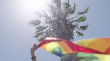 Gurur yürüyüşü sırasında gökkuşağı bayrağının yavaşça dalgalanması.