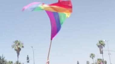 Gurur yürüyüşü sırasında gökkuşağı bayrağının yavaşça dalgalanması.