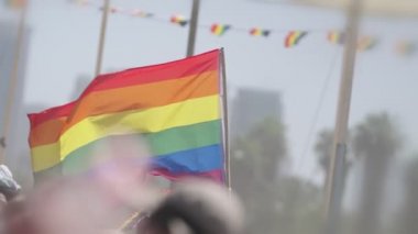 LGBTQ gökkuşağı bayrağı ana parti sırasında ağır çekimde sallanıyor.