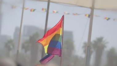 LGBTQ gökkuşağı bayrağı ana parti sırasında ağır çekimde sallanıyor.