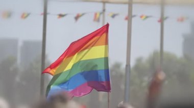 LGBTQ gökkuşağı bayrağı ana parti sırasında ağır çekimde sallanıyor.