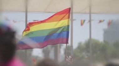LGBTQ gökkuşağı bayrağı ana parti sırasında ağır çekimde sallanıyor.