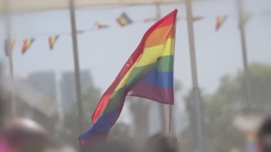 LGBTQ gökkuşağı bayrağı ana parti sırasında ağır çekimde sallanıyor.