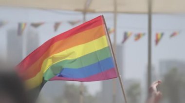 LGBTQ gökkuşağı bayrağı ana parti sırasında ağır çekimde sallanıyor.