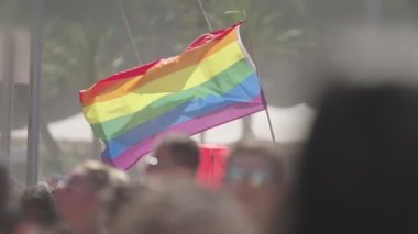 LGBTQ gökkuşağı bayrağı ana parti sırasında ağır çekimde sallanıyor.