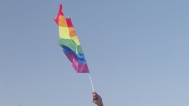 LGBTQ gökkuşağı bayrağı ana parti sırasında ağır çekimde sallanıyor.