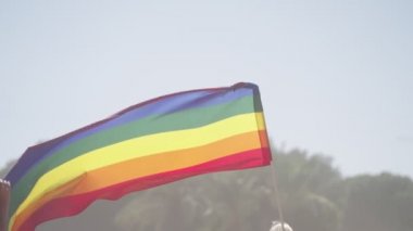 LGBTQ gökkuşağı bayrağı ana parti sırasında ağır çekimde sallanıyor.