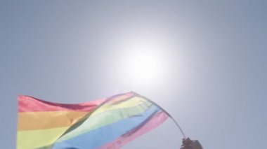 LGBTQ gökkuşağı bayrağı ana parti sırasında ağır çekimde sallanıyor.