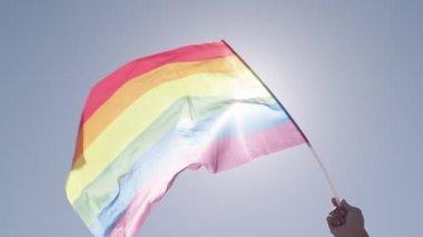 LGBTQ gökkuşağı bayrağı ana parti sırasında ağır çekimde sallanıyor.