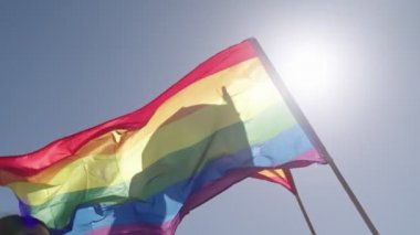LGBTQ gökkuşağı bayrağı ana parti sırasında ağır çekimde sallanıyor.