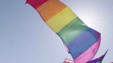 LGBTQ gökkuşağı bayrağı ana parti sırasında ağır çekimde sallanıyor.