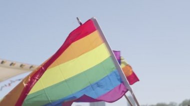 LGBTQ gökkuşağı bayrağı ana parti sırasında ağır çekimde sallanıyor.