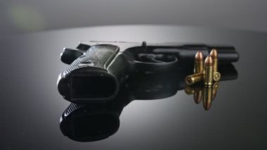9mm gun rotating on a reflective surface