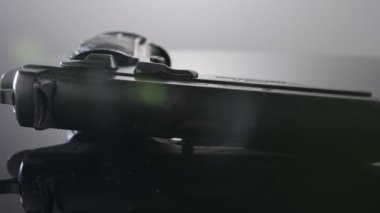 9mm gun rotating on a reflective surface