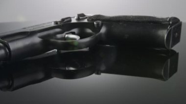 9mm gun rotating on a reflective surface
