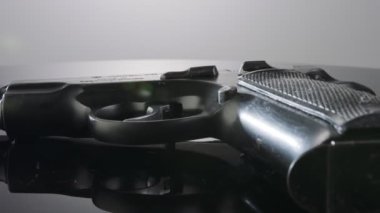 9mm gun rotating on a reflective surface